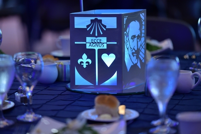 Lit up St. John's logo lamp and St. Vincent de Paul portrait at table