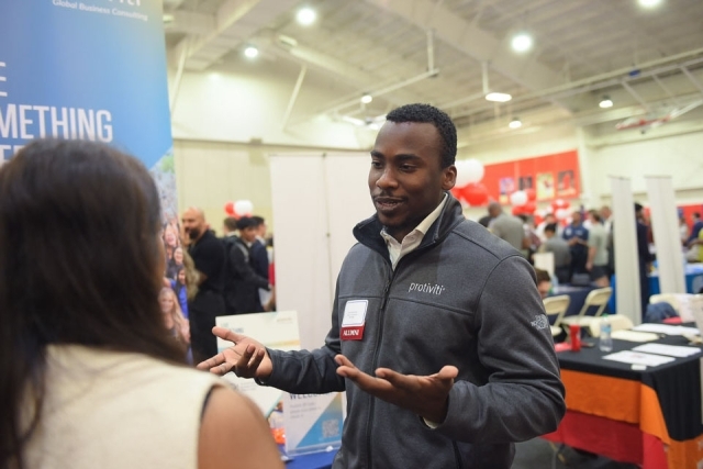 male speaking with woman at table
