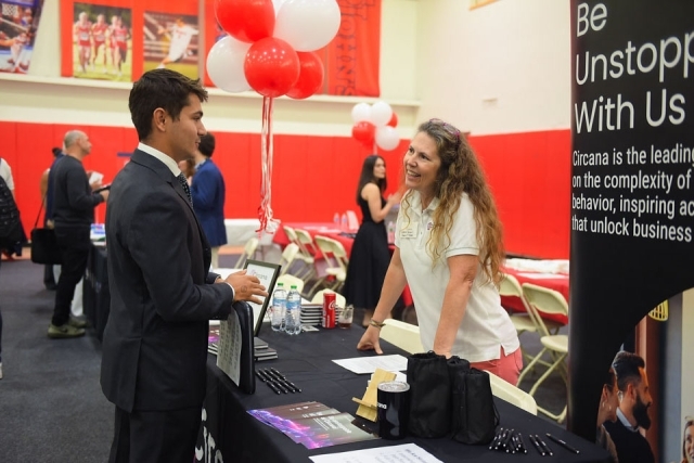 Student and recruiter speaking at table
