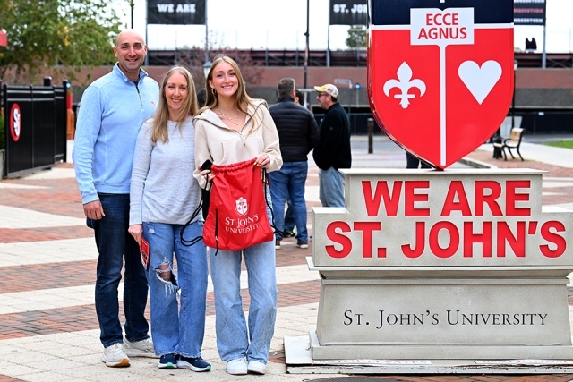 Parents and female high school student by We Are St. John's statue