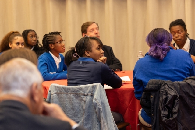 Group of young adults listening to a speaker 