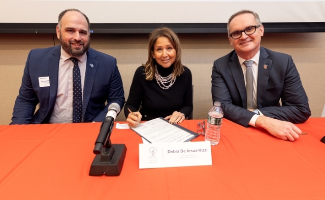 three panelists at a red table 