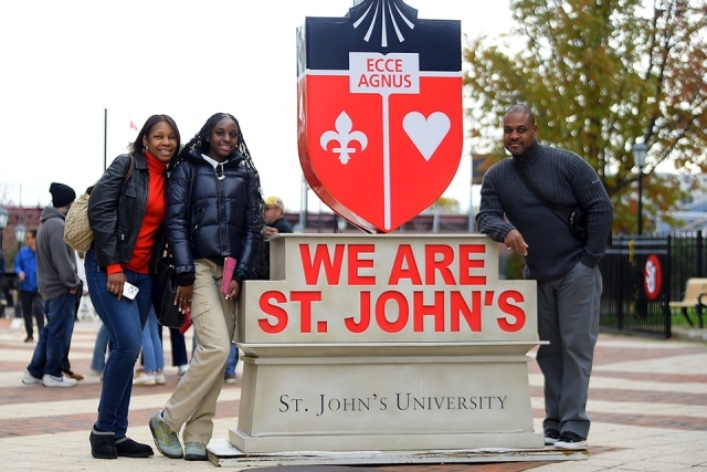 Prospective students and family by St. John's statue
