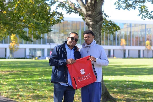 Prospective student and parent holding up backpack