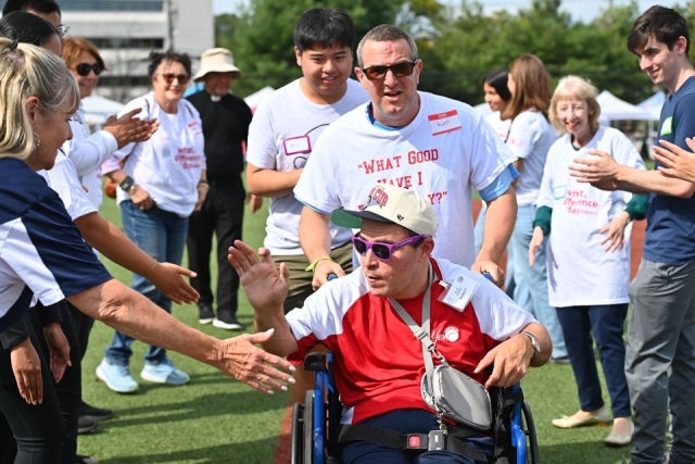 Service Day participant pushing man in wheelchair
