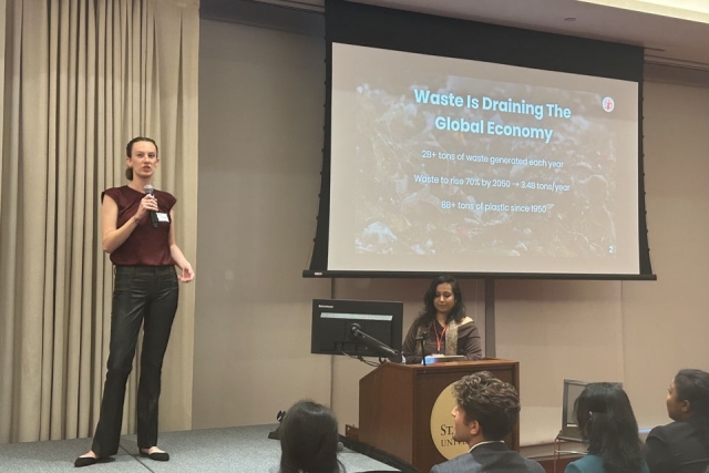 Cara Dunleavy speaking at front of room