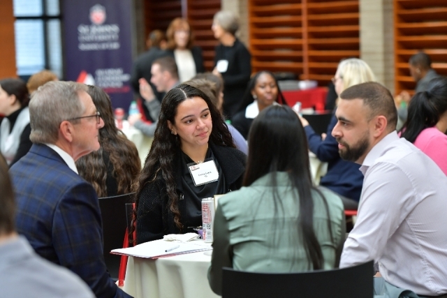 Participants in this year's Pro Bono Working Lunch sit around a table having a discussion.
