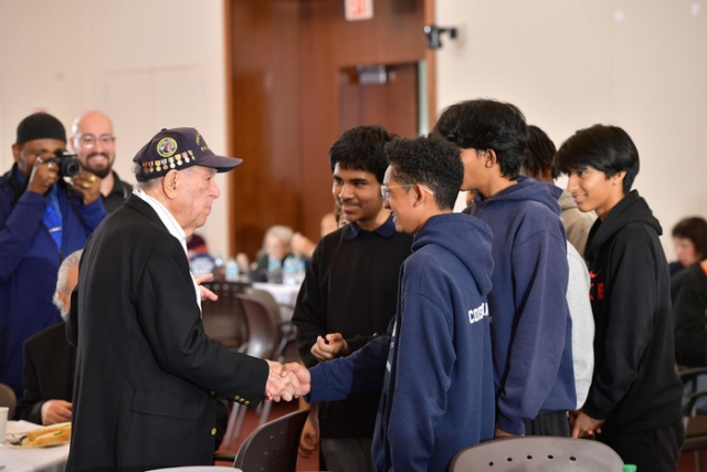 Group of college students talking to a vertan 