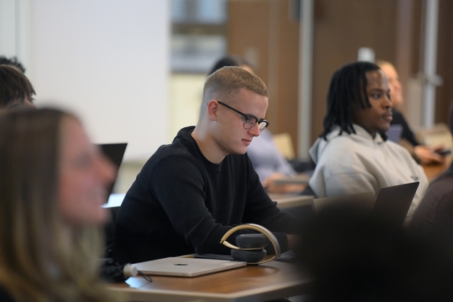 Male student looking a his computer during a lecture