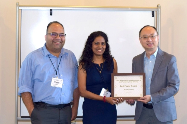 Young woman recieving an award by 2 St. John's Faculty, Left and right of her 
