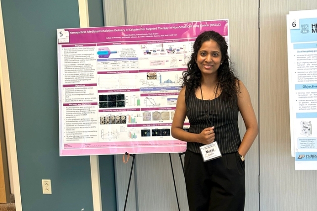 Young women standing in front of presentation board 