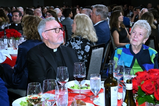 Priest and female attendee seated at table