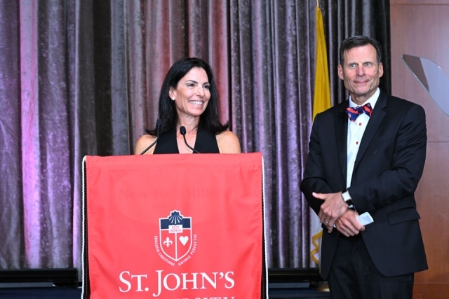 Woman speaking at podium with man beside her