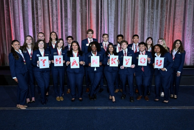 President's Society members holding up "THANK YOU" papers