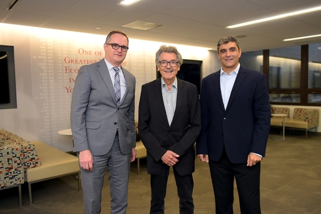 Three men in suits smiling