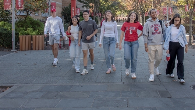 Students walking together outside on Queens campus
