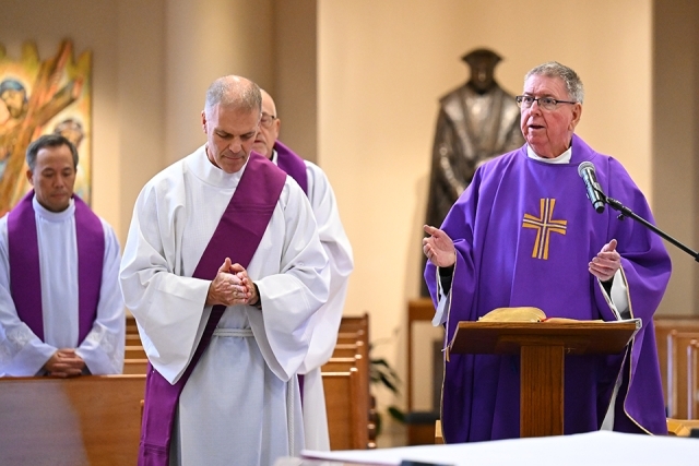 priest speaking during service at ambo