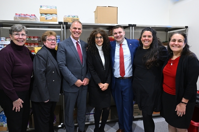 Group of people standing smiling in food pantry