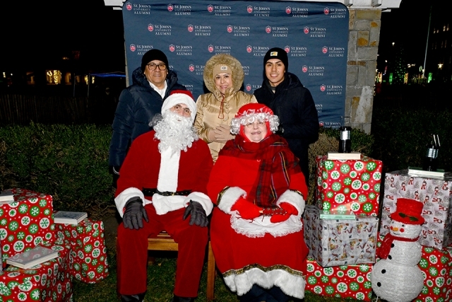 Santa and Mrs. Claus with three adults standing behind them
