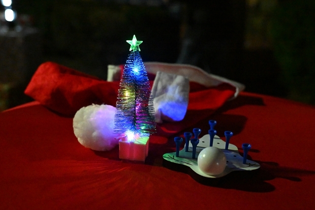 Tiny lit up tree and other decorations on a table