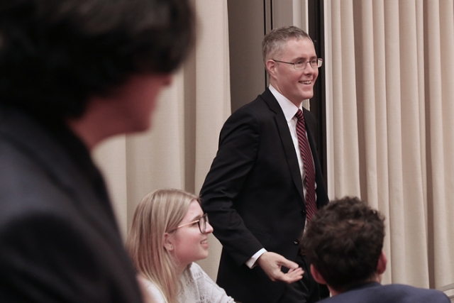 Faculty member speaking with students during an interactive classroom discussion.