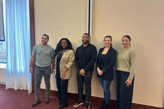 Group of men and woman posing for a photo smiling 