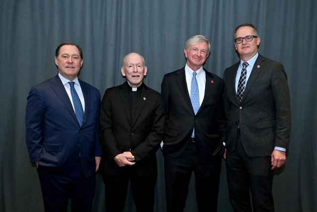 Four formally dressed attendees standing together and posing for a photo at the Insurance Leader of the Year Award Dinner.