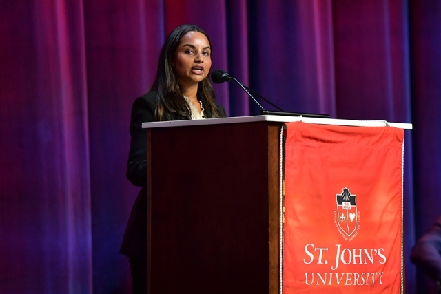 Speaker standing at a podium with St. John’s University branding, addressing the audience during the Insurance Leader of the Year Award Dinner.