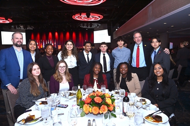 Students and guests posing together at a banquet table during the Insurance Leader of the Year Award Dinner.