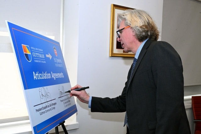 man signing his signature on a board 
