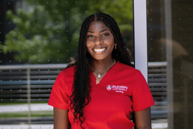 St. John's University nursing student in red scrubs 