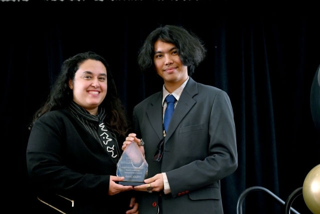 Award recipients standing on stage holding glass awards during the Martin Luther King Jr. Legacy Dinner.