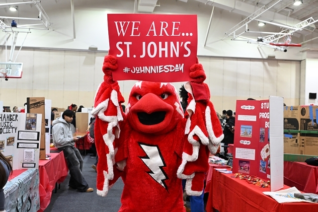 a red bird mascot holding up a sign 