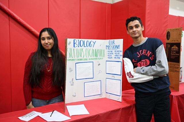 2 students next to a presentation board 