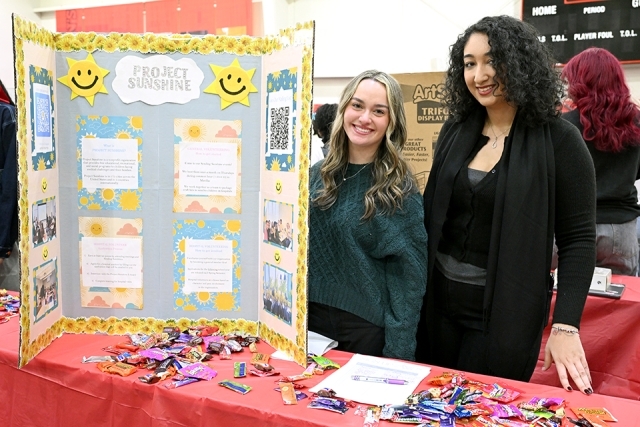 2 students at a presentation table 