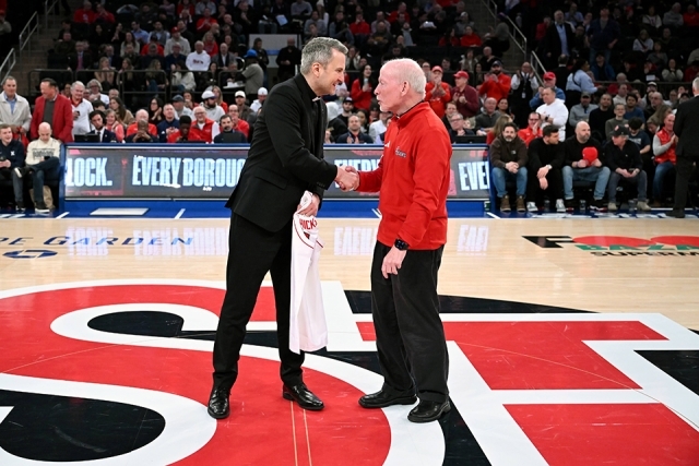 Archbishop Hicks shaking Fr. Shanley's hand on MSG court