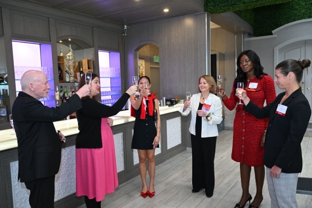 Group of women and male priest cheering with a glass 