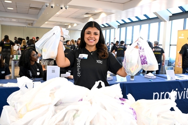 Student holding up plastic bags filled with food 