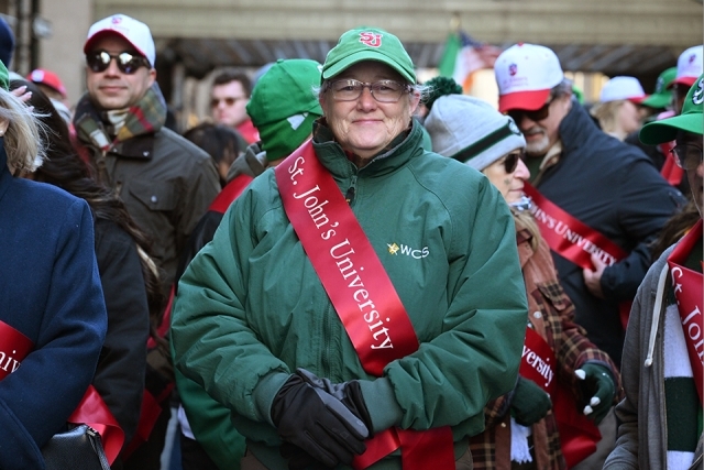 St. John’s University alumni wearing red sash during a St. Patrick’s Day parade