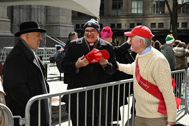 St. John’s University alumnus greeting a member of the clergy during a St. Patrick’s Day parade
