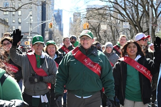 Group of St. John’s University students and alumni walking together during a St. Patrick’s Day parade in New York City