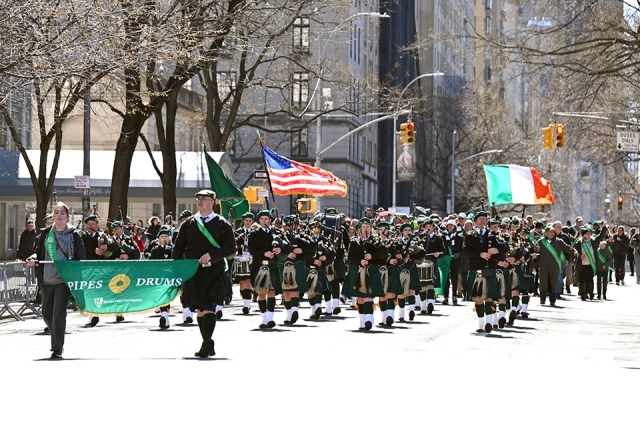 Pipes and drums band performing with American and Irish flags during a St. Patrick’s Day parade in New York City