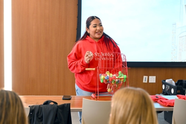 Woman speaking in front of a projector screen 