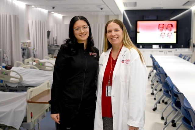 Women in black standing next to nursing student 