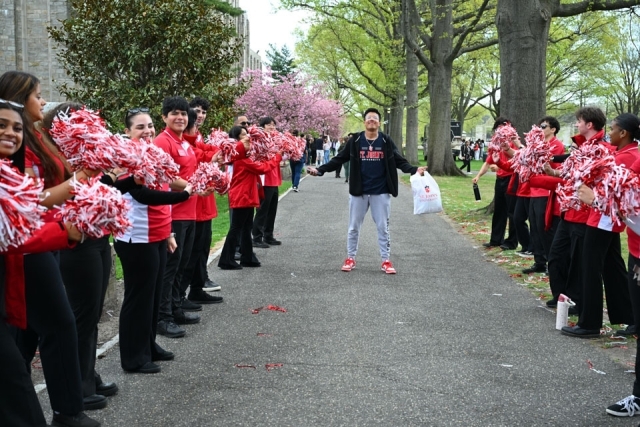 Student standing in the middle of group of ambassadors on campus 