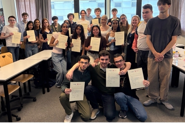 Students holding up papers