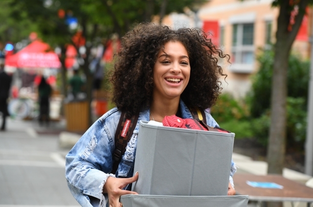 Female student carrying box