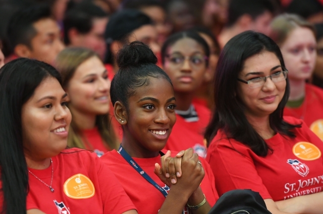 Candid shot of 3 female students sitting in a crowd