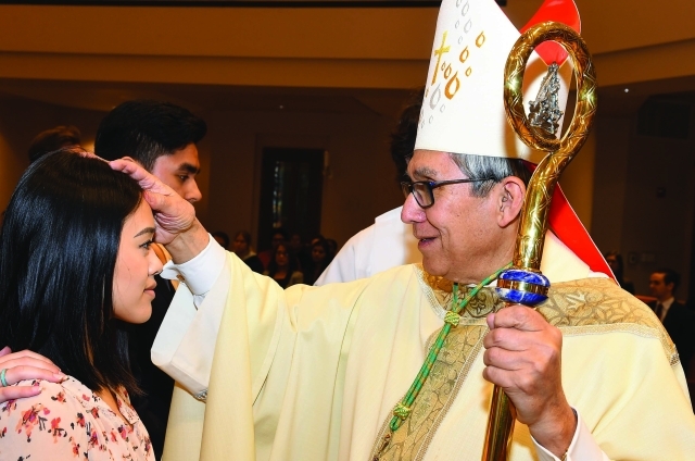 Male priest blessing female student