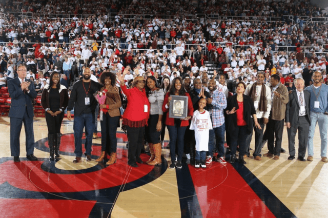 Solly Walker's family holding photo of him on the floor of Carnesecca Arena